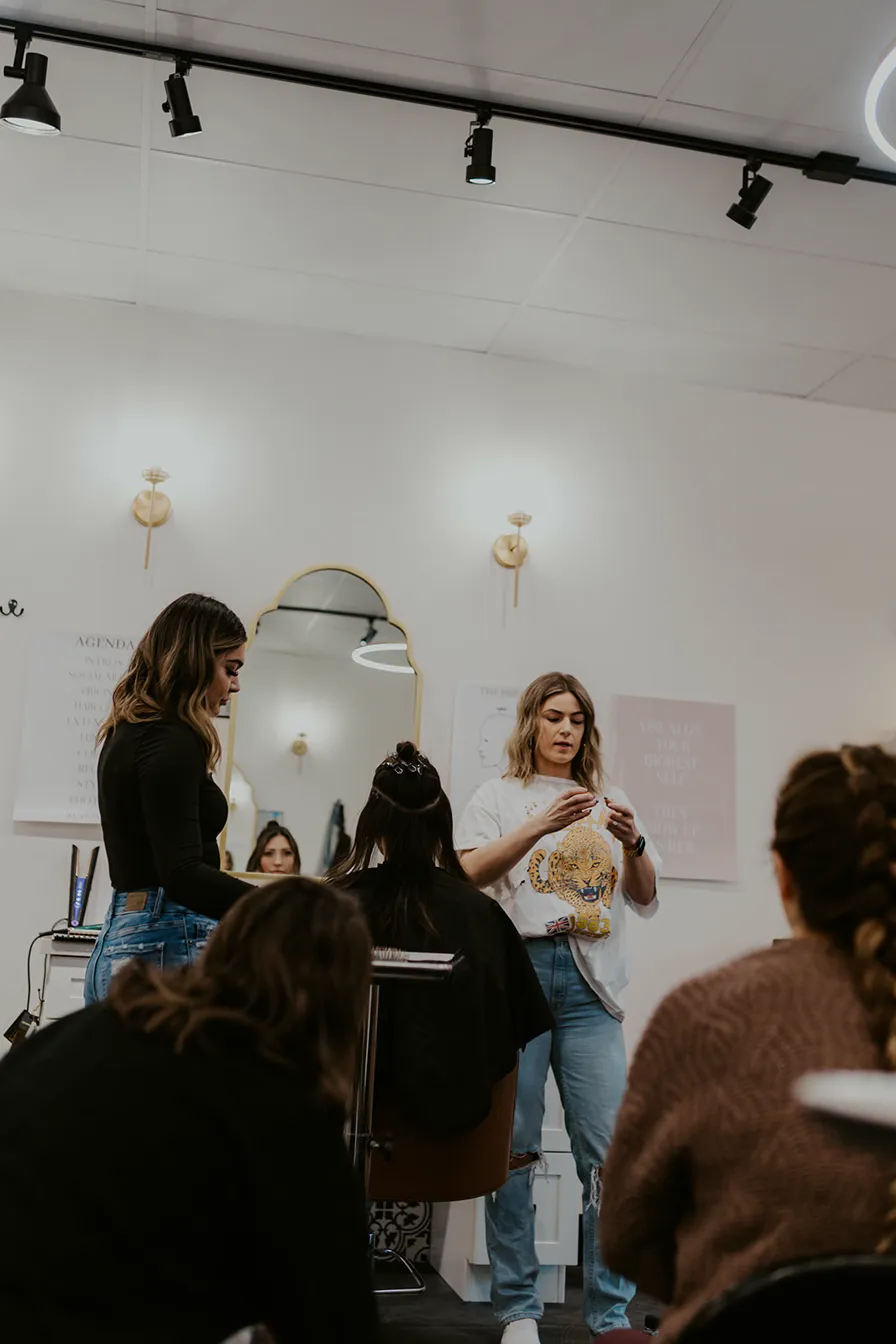 Siera teaching extension techniques to a group of stylists