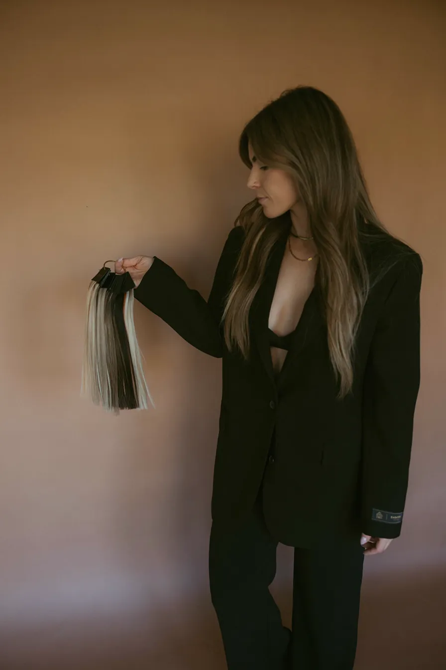 Siera, owner of Desert Strands, holding hair extensions